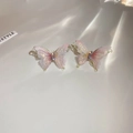 Vue détaillée des boucles d'oreilles papillon en tissu rose avec cristaux et aiguilles en argent. - Rose