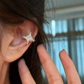 Detailed close-up showing a sparkling zircon star ear cuff elegantly worn on the ear bone - Ear Cuffs / Single Piece / Silver