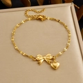 Elegantes goldenes Armband mit Schleife und Herzanhänger auf Schmuckschatulle - Gold Schleife Herz Anhänger Armband (B2087)