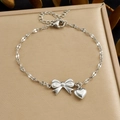Silbernes Edelstahl-Kettenarmband mit Schleifen- und Herzanhänger auf Schmuckbox - Silber Schleife Herz Anhänger Armband (B2088)