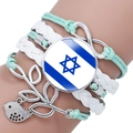 Macro detail of multi-layer woven bracelet with Israel flag glass gem and infinity charm - Cyan