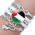 Close-up of multilayer Palestine flag infinity bracelet with bird charm on wrist - Lake Blue