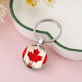 Dettaglio macro del ciondolo con bandiera canadese su portachiavi in metallo vintage - Foglia d'Acero Rossa e Bianca Artistica Invecchiata (CC002398-4)