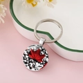 Detailed shot of Canadian maple leaf glass dome keychain on a ceramic tray with dry flowers - Red Maple Leaf and Grey Pebble Style (CC002398-12)
