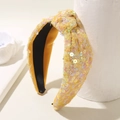 Detailed view of yellow sequined headband with top knot design on white stand - 3# Knot Yellow