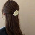Golden shell-shaped metal hair claw clip shown from the back on curly brown hair - Gold / Small Shell Style