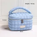 Soft light blue quilted cosmetic bag with cloud-like texture and dual zipper closure - Blue Bucket Bag