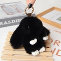 Detailed macro view of black plush rabbit keychain with gold clasp and white leather paws - Large / Black
