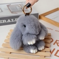 Gray faux fur bunny keychain with golden clasp held by hand for scale display - Large / Medium Grey