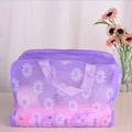 Detail of purple translucent waterproof cosmetic bag with white daisy prints and top handle - Purple
