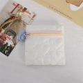 Detailed view of white quilted heart pattern coin purse with silver ring zipper closure - White
