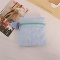 Close-up of light blue quilted heart coin purse with round metal zipper and side strap - Blue