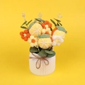 Close-up of hand-knitted lemon and floral bonsai with ceramic vase and jute bow decoration - Orange Style