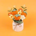 Detailed texture of handmade crochet orange persimmons and knitted flowers in a ceramic vase - Persimmon Style