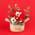 Dettaglio del bouquet di fragole all'uncinetto in vaso beige su sfondo rosso acceso - Stile Fragola