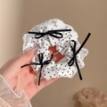 Witte polkadots haarelastiek met kanten randen en zwarte fluwelen strikjes in de hand - #2 Zwarte Strik - 14 Cm