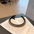 Close-up of a vintage headband with black crystals and gold chain on old paper - Black (F036-Black)