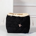 Detail of black quilted drawstring makeup bag with pink embroidered letter K detail - Embroidered Black Bow