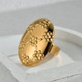 Anello ovale dorato vintage con motivo floreale a rilievo e finitura lucida su vassoio in pietra - Anello a Scudo Ovale con Rilievo Floreale (R760)