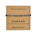 Detail of Morse code bracelet featuring dark beads and Good Luck gift card on white background - Good Luck