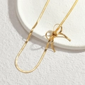 Minimalist gold bow-shaped snake bone chain necklace for women on a white stone tray - Gold (Necklace)