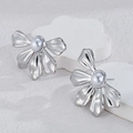 Pendientes de flores plateadas con perlas barrocas sobre pedestales blancos - Color Acero