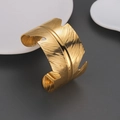 Detail of 18k gold plated stainless steel cuff bracelet with intricate feather texture - Feather Shape Style