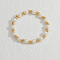 Makro-Detail des Perlenarmbands mit weißen Perlen und Goldakzenten auf weißem Hintergrund - Perlen und Goldperlen Armband (OLBB1093-ptk)