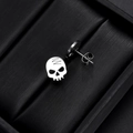 Detailed close-up of silver skull earrings with butterfly backing on black texture - Skull Head - Steel Color