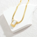 Detailed view of curved bar pendant on flat snake chain over white marble base - White Mother of Pearl Style (Style 5)