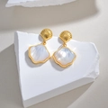 Détail de boucles d'oreilles en forme de coquille dorée avec nacre irisée - Boucles d'Oreilles Coquillage Dorées en Nacre