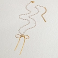 Elegant pearl necklace featuring a golden bow pendant and S-STEEL charm on a textured background - White Pearl Chain Gold Bowknot Style