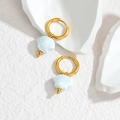 Detail von 18K Gold Muschelohrringen mit hellblauen Anhängern auf weißem Hintergrund - Hellsee-Blau