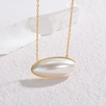 Minimalist double layer gold necklace with a large oval white faux pearl pendant on marble - Necklace