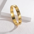 Elegant gold-plated wide bangle with star-shaped crystals and beaded edge on white background - White Zirconia