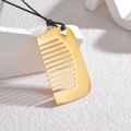 Colgante de peine dorado con cordón negro sobre un soporte minimalista blanco puro - Dorado