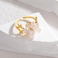 Adjustable gold titanium ring with crystal flower design shown from a high angle view - White