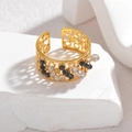 Retro-Ring mit hohlem Geometrie-Muster und bunten Perlen auf weißem Steinsockel - Schwarz