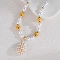 Détail du collier de perles avec des fleurs dorées et un pendentif en perle goutte - Style Pavé Goutte d'Eau (OLBN2213-F)