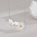 Detalle de collar con colgante de corazón y margarita sobre pedestal blanco texturizado - Color Acero