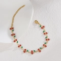 Dettaglio di un bracciale a ciliegia dorato con ciondoli glitter rossi e chiusura - Rosso