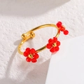 Dettaglio anello regolabile dorato con fiori in cristallo rosso su sfondo strutturato - Rosso (R848-hong)
