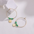 Close-up of gold hoop earrings with green beads and a daisy floral pendant on a stone block - Green Beaded Daisy Flower Style (E412-hua)