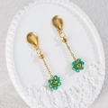 Elegant gold flower tassel earrings with green faceted beads on a white embossed tray - Green (E1104-lv)