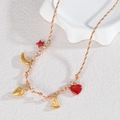 Detail einer bunt gewebten Halskette mit goldenen Anhängern wie Stern und Früchten - Orange Grün Weiß Geflochtenes Seil-Tropische Frucht (N2228-B)