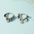 Makroaufnahme silberner Creolen mit polierten, baumelnden Metallplättchen im Detail - Silber