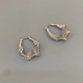 Primer plano de pendientes geométricos de metal plateado con diseño de alambre enrollado - Plateado