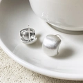 Minimalistische geborstelde zilveren oorbellen met halfrond ontwerp op keramiek - Geborsteld Zilver