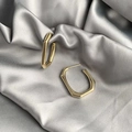 Polished gold geometric rectangular hoop earrings on luxurious silver silk background - Rounded Rectangle Style / Gold