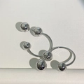 Detail of high-polish silver metal ball earrings with unique U-shaped minimalist design - White Gold
